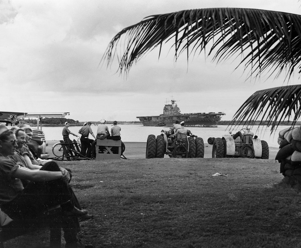 Enters Pearl Harbor, 26 May 1942. She left two days later to take part in the Battle of Midway. Photographed from Ford Island Naval Air Station, with two aircraft towing tractors parked in the center foreground. Official U.S. Navy Photograph, now in the collections of the U.S. National Archives.