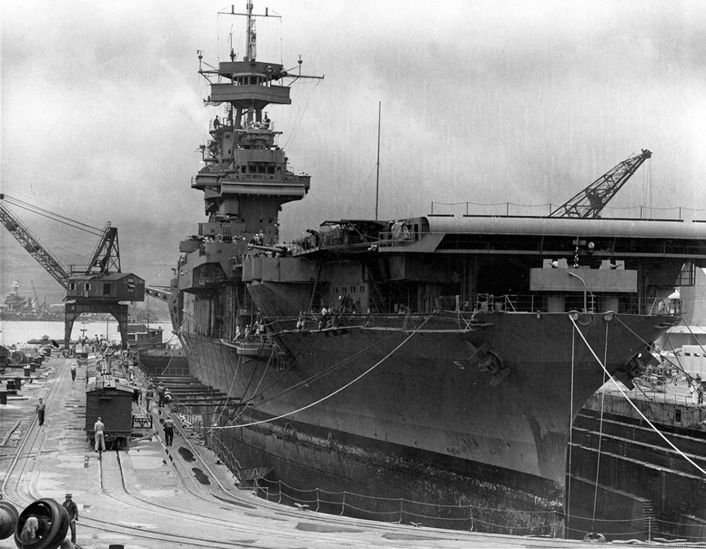In Dry Dock # 1 at the Pearl Harbor Navy Yard, 29 May 1942, receiving urgent repairs for damage received in the Battle of Coral Sea. She left Pearl Harbor the next day to participate in the Battle of Midway. USS West Virginia (BB-48), sunk in the 7 December 1941 Japanese air attack, is being salvaged in the left distance. Official U.S. Navy Photograph, now in the collections of the National Archives.