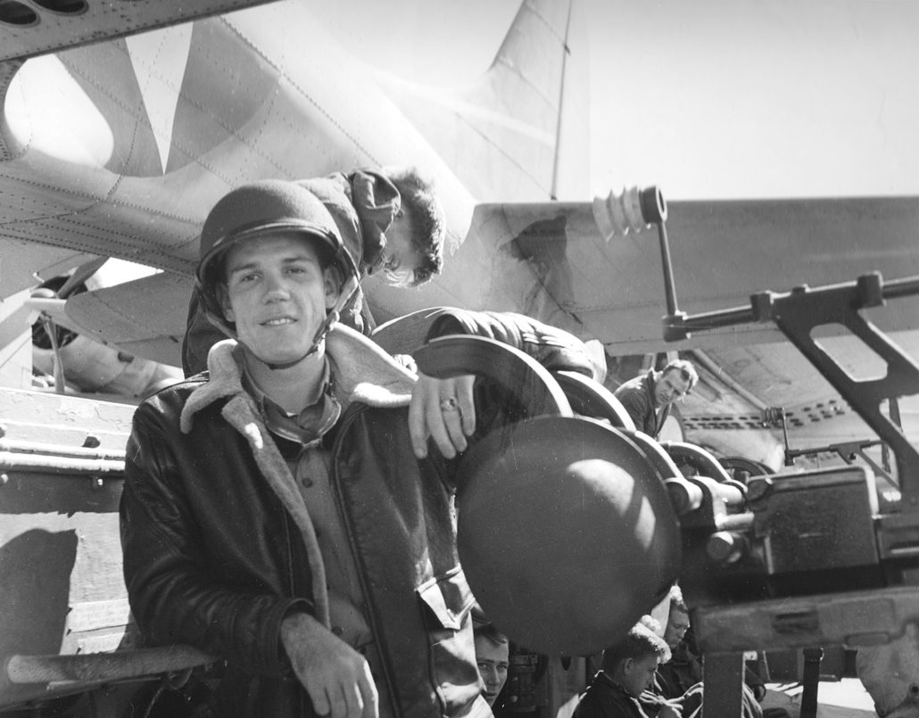 An junior officer poses with a 20mm gun on USS Yorktown (CV-5), during the morning of 4 June 1942. This gun is one of five in Yorktown's after port 20mm battery. Several SBD-3 Dauntless scout bombers are parked on the flight deck alongside these guns. Note the officer's leather jacket, goggles and barely visible rank bar on his collar. Also note the white rubber eye cup on the gun's open sight. These eye cups were still present on some of Yorktown's 20mm guns when she was examined in May 1998. Official U.S. Navy Photograph, now in the collections of the National Archives.