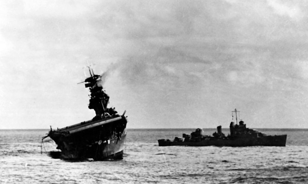 USS Yorktown (CV-5) being abandoned by her crew after she was hit by two Japanese Type 91 aerial torpedoes, 4 June 1942. USS Balch (DD-363) is standing by at right. Note oil slick surrounding the damaged carrier, and inflatable life raft being deployed off her stern. Official U.S. Navy Photograph, now in the collections of the National Archives.